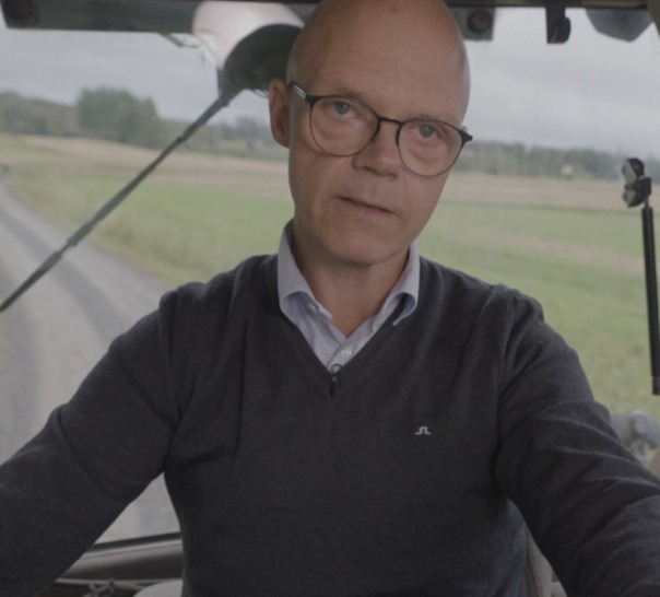 Person sedd framifrån som kör traktor