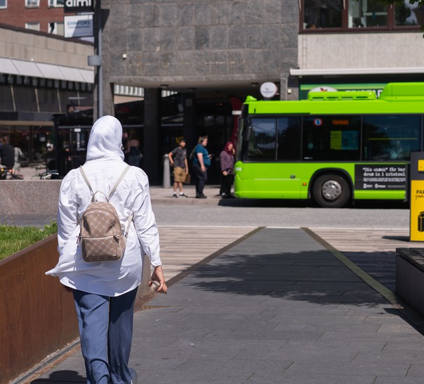 Person promenerar mot en buss.
