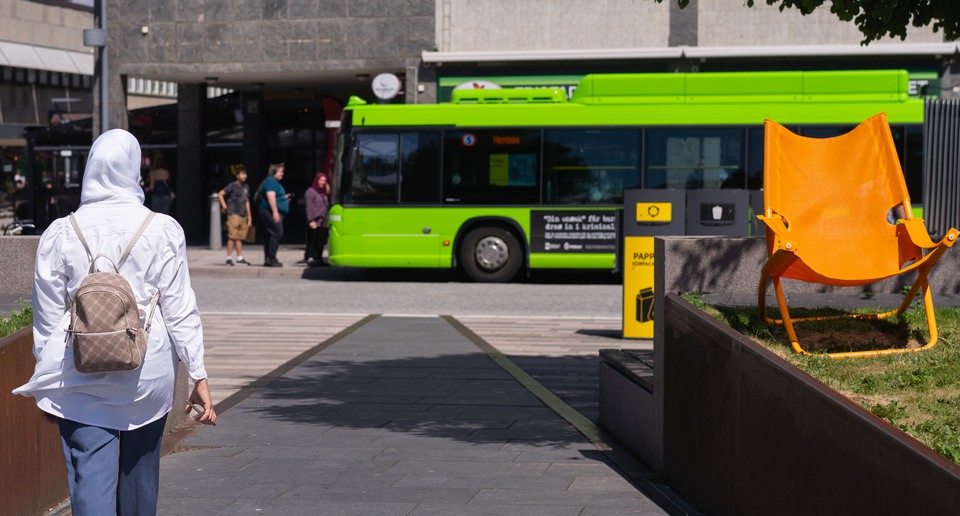 Person promenerar mot en buss.