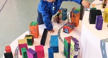 Barn som leker med färgglada staplar