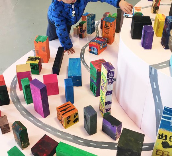 Barn som leker med färgglada staplar