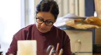 Människa som arbetar fokuserat och tittar ned på sitt skrivbord