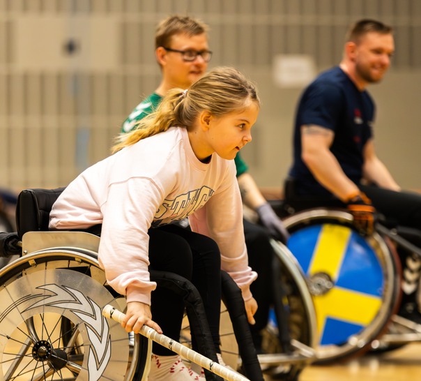 Unga i rullstol som spelar innebandy.