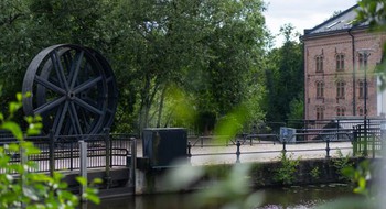 Gångbro och tegelhus i bakgrunden.
