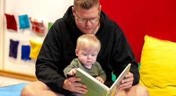 Person som läser bok för ett litet barn.