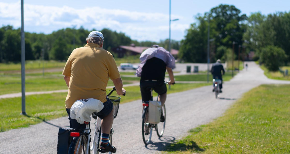 Tre cyklister på en cykelväg.