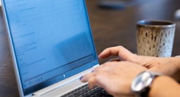Händer som skriver på en laptop.