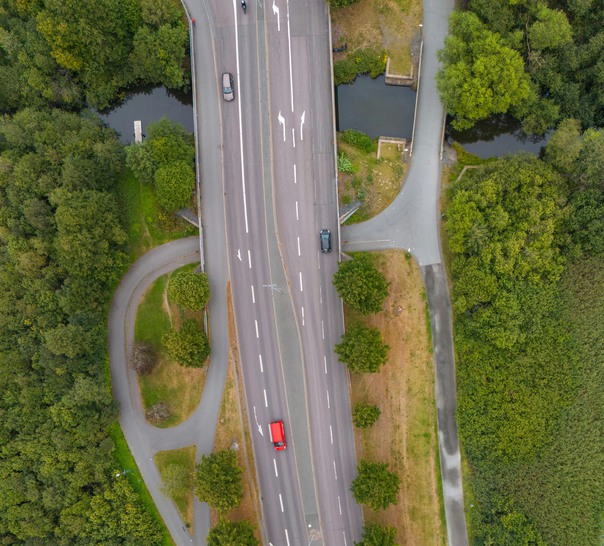 Flygfoto över väg med grönska runtomkring.