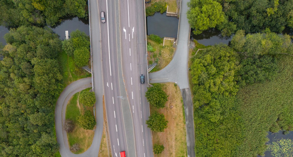 Flygfoto över väg med grönska runtomkring.