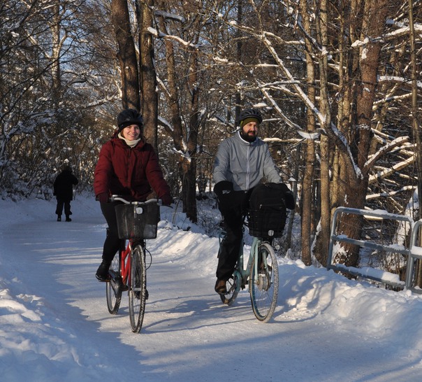 Två personer cyklar på en snöig cykelbana.
