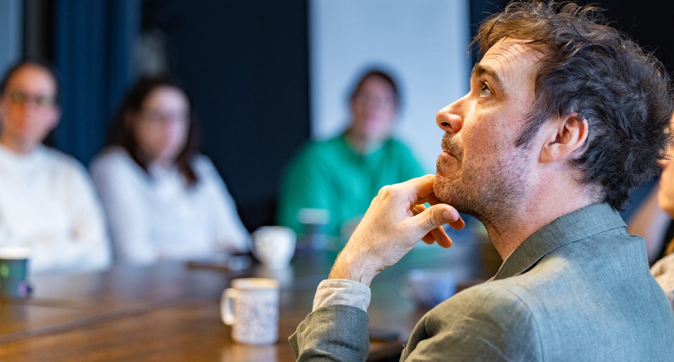 En grupp människor som sitter runt ett träbord.