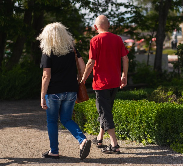 Två personer som är ute och går håller varandra i handen.