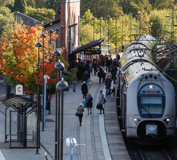 Ett tåg står vid en perrong med människor.
