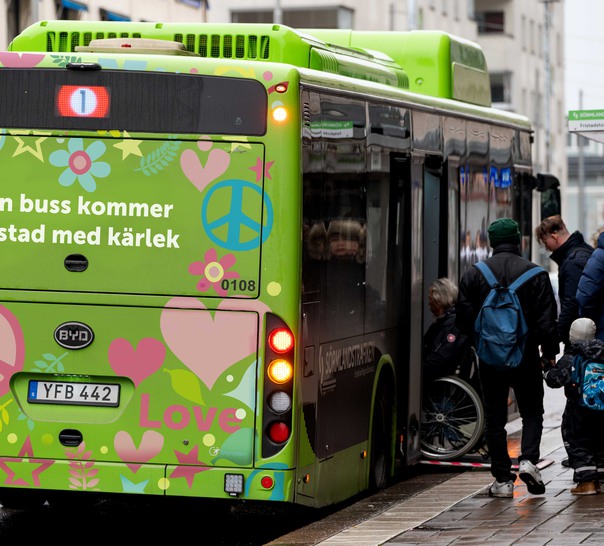 En grön buss med kärleksfulla symboler på baksidan. 