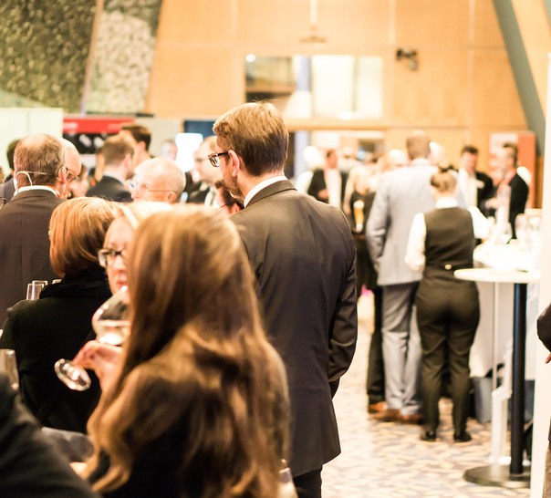 Människor står och minglar.