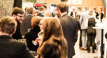 Människor står och minglar.