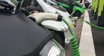 Flera elbilar på rad som laddas.