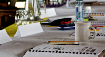 Bord med pennor, block, namnskyltar och glas.