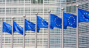 Flaggor med EU:s symbol, gula stjärnor mot en blå bakgrund.