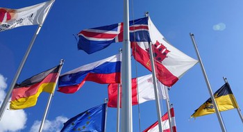 Flaggor vajar mot en blå himmel.