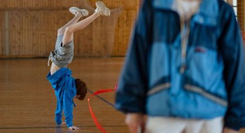 Barn står på händer i gymnastiksal.