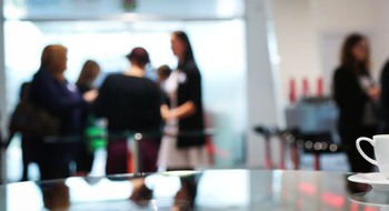 Personer som minglar runt små ståbord.