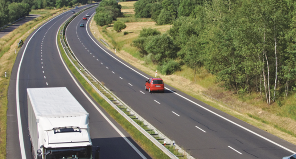 Lastbil och personalbilar på motorväg.
