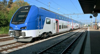 Ett Mälartåg åker förbi en tågstation.