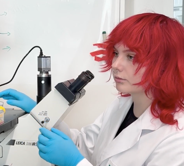 Forskaren Marina Peltonen vid ett mikroskop.