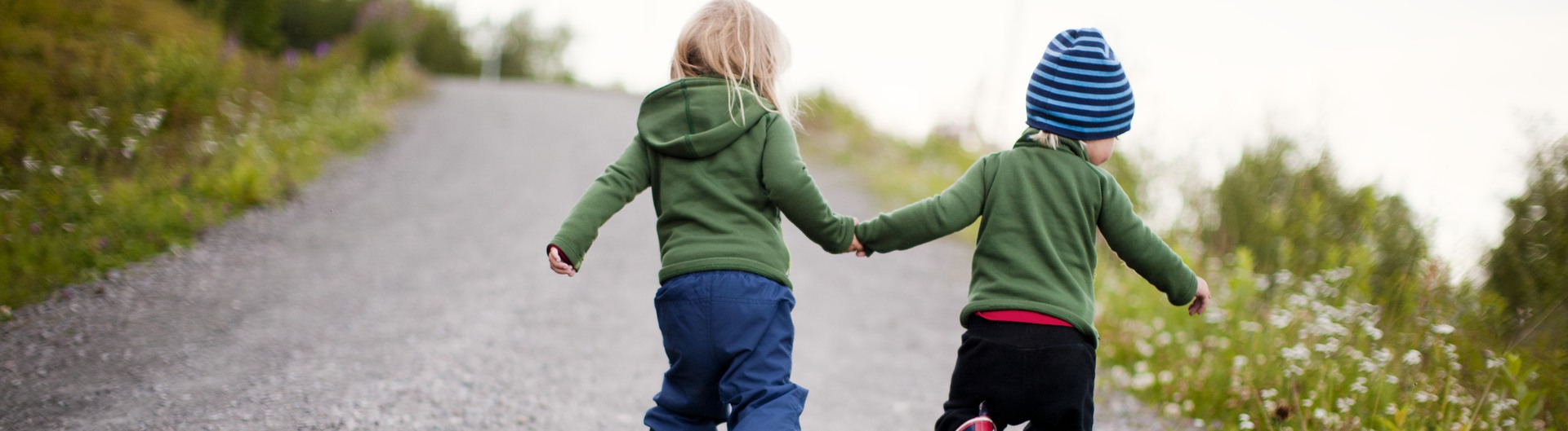 Två barn som håller varandra i händerna.