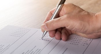 Person som fyller i en pappersenkät.