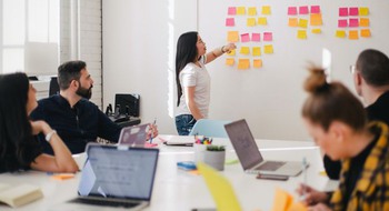 Fyra personer och en whiteboard med post-it-lappar.
